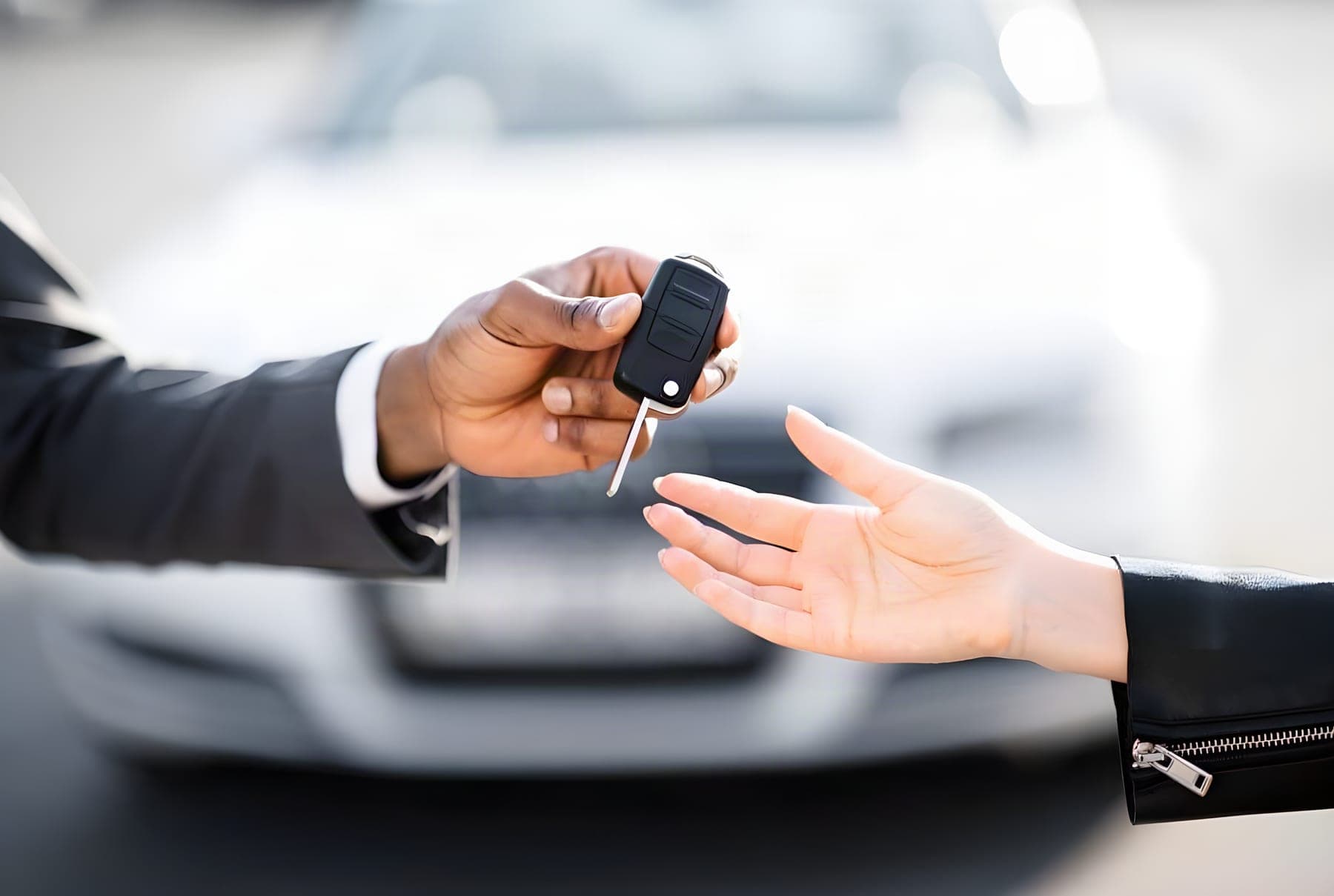 Consultor entregando a chave de um carro a uma cliente